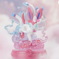 Animated character figure on a pink base with a soft, blurred background